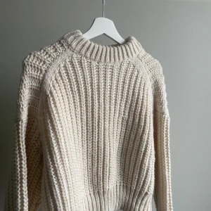 Beige stickad tröja - Mysig beige stickad tröja med grovt mönster och rund hals. Perfekt för kyliga dagar med sin varma och bekväma design. Tröjan har långa ärmar och en ribbad kant vid halsen. Från HM, använd fåtal gånger!
