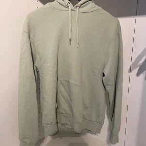 Grön hoodie - Mintgrön/Pastelgrön hoodie från Monki! Har ett litet håll på baksidan av axeln och en gul fläck på luvan men inget som syns.