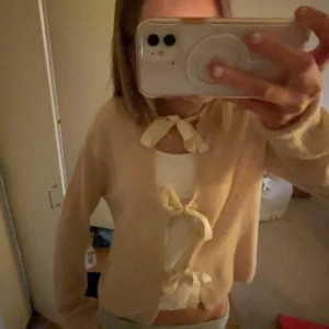 Ljusrosa kofta med rosetter - Super söt, och nästan aldrig använd!! Man han ha den på lite olika sätt🥰Priset kan diskuteras 