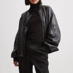 Svart bomberjacka från NA-KD - Svart oversized bomberjacka från NA-KD. Jackan är gjord av PU och har långa armar, fickor fram samt på ena armen. Originalpris 1099kr!