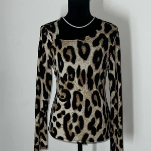 Leopardmönstrad långärmad topp - Snygg leopardmönstrad topp med långa ärmar och fyrkantig halsringning. Perfekt för att ge en djärv touch till din outfit.