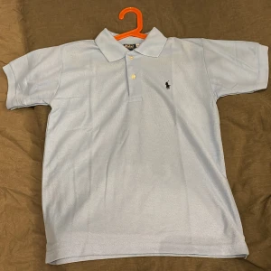 Ljusblå Ralph lauren piké - Helt ny, aldrig använd Ralph lauren piké för ett riktigt bra pris. Hör av er vid frågor. Pris kan diskuteras vid snabb affär. 