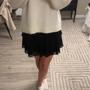 Svart volangkjol - Säljer en svart kortkjol med volanger från Chelsea. Kjolen har en elastisk midja som ger en bekväm passform. Perfekt för att styla med en stickad tröja eller en snygg topp. Den är helt ny och oanvänd, mycket bra skick, nypris 500kr. Säljer i storlek S och XS