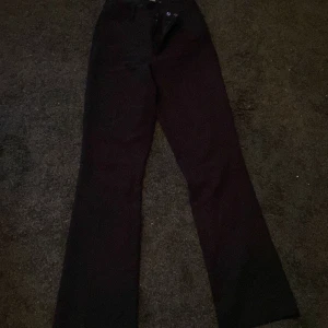 Svarta byxor från Bik Bok - Snygga svarta byxor från Bik Bok i en klassisk stil. Byxorna har en hög midja och raka ben, vilket ger en stilren look. Perfekta för en chic och elegant outfit.