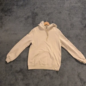 Beige hoodie - Säljer en stilren beige hoodie. Den har en klassisk design med huva, perfekt för en avslappnad look.