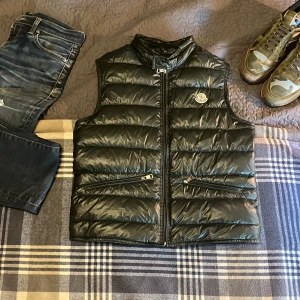 Moncler gui vest -  Hej hej allihopa just nu så säljer jag min gamla mörk gröna Moncler gui väst. Västen är i storlek 1 vilket översätt till en S i vanliga storlekar. Västen har ett pyttelitet håll på framsidan som är nästintill osynligt när den används.Äkthetbevis genom koden(Slide 5).Nypris är runt 5500 medan jag säljer den för endast 2499 Tar självfallet emot byten och priset kan alltid diskuteras. MVH Oscar