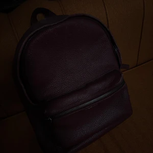 Röd ryggsäck från Michael Kors - Snygg röd ryggsäck från Michael Kors i skinn. Använt skick- några små missfärgningar på utsidan men väldigt fräsch inombords. 