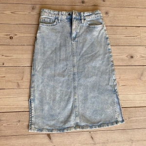 Ljusblå jeanskjol - Jag säljer en ljusblå jeanskjol från Lindex i storlek 140, jag har aldrig använt den samt att den är i väldigt bra skick.