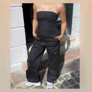 Zara Cargo Jumpsuit 🖤 - Söt svart cargo jumpsuit från Zara🖤Jag hade skräddarsytt dem lite kortare så att de passar mig och jag är 164 cm. Storlek S men skulle nog också kunna passa XS! 💕 Säljer för 190