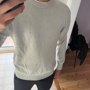 Stickad tröja från H&M - Säljer en stilren beige stickad tröja från H&M i relaxed fit. Perfekt för både höst och vinter med sin bekväma passform. Tröjan har långa ärmar och ribbade muddar vid ärmslut och nederkant. Tröjan har storlek M och säljs för 149kr