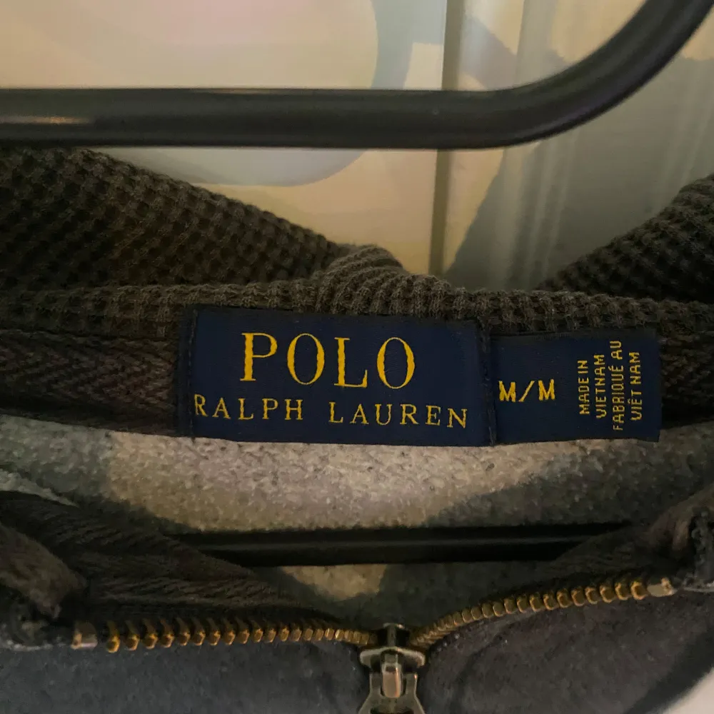 Säljer en snygg grå hoodie från Polo Ralph Lauren. Den har en dragkedja framtill och en klassisk huva med vita snören. Perfekt för en avslappnad stil och passar bra till både höst och vår. Den är i bra skick. Tveka inte att höra av er vid funderingar. Hoodies.