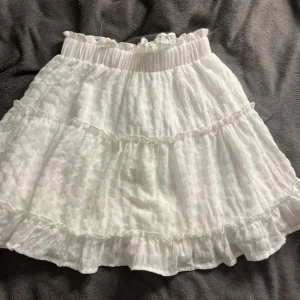 Vit volangkjol - Säljer på grund av att den inte blir använd. Köpt på plick. Små fläckar som inte syns