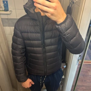 Colmar dunjacka - Svart colmar jacka med luva.  Ett litet hål på axeln som lagats med en lapp Nypris ca 5500kr Kvitto finns.  Killen på första bilden är 189 90 kg Killen på andra bilden är 175 så skulle säga att jackan passar för någon där emellan