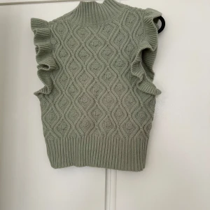 Grön stickad väst i storlek S - Jättefin stickad väst i storlek s, kort modell använd ett fåtal gånger så den är i nyskick. 