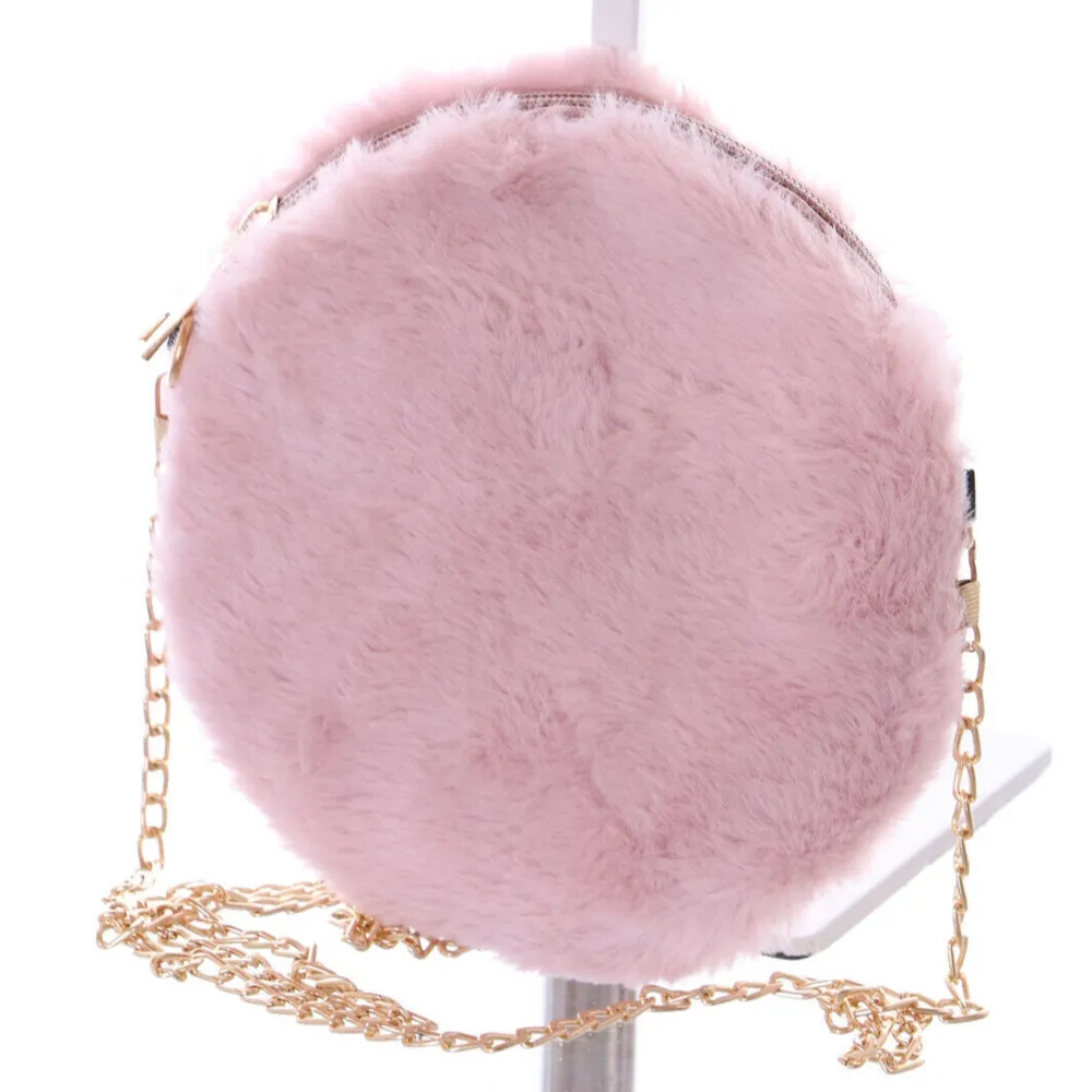 Supergullig rund väska i fluffigt rosa material. Den har en snygg guldfärgad kedja som axelrem och en dragkedja upptill. Perfekt för att ge en söt touch till din outfit!. Väskor.