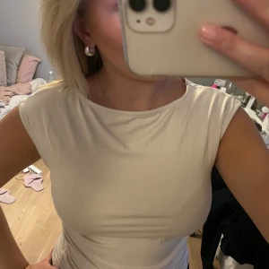 Beige topp - Beige topp som är ihop dragen i sidorna av midjan, använd 1 gång!🤍