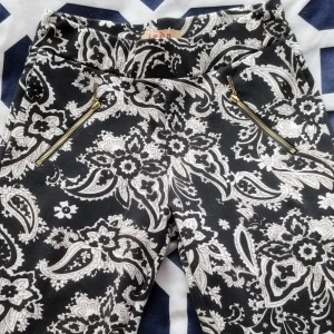 Svartvita mönstrade byxor från Jada - Säljer ett par snygga svartvita byxor från Jada i storlek S (mer lika XS). De har ett coolt blommigt mönster och dragkedjor framtill som ger en extra touch. Skinny jeans bundle är 50kr (för alla skinny jeans)