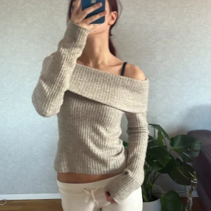 Grå ribbad offshoulder tröja från H&M - Säljer en superfin grå ribbad offshoulder tröja från H&M! Den är perfekt för höst och vår med sin mysiga och stilrena design. Tröjan har långa ärmar och en tight passform som sitter snyggt på kroppen💕