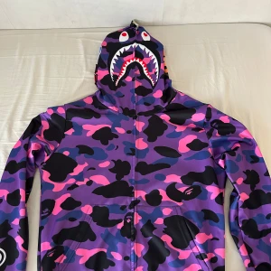 Färgglad camo hoodie med hajmotiv - Säljer en multifärgad bape zip hoodie i storlek M. den är helt ny och ligger i bra skick👍🏽 