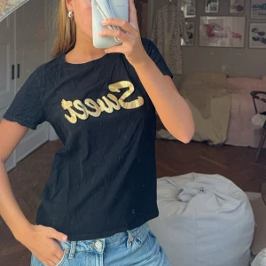 Svart t-shirt med guldtext - Säljer en svart t-shirt med texten 'Sweet' i glittrigt guld på bröstet. Den är kortärmad och har en normal passform. Perfekt för en avslappnad stil eller en utekväll. Passar bra till jeans eller kjol!