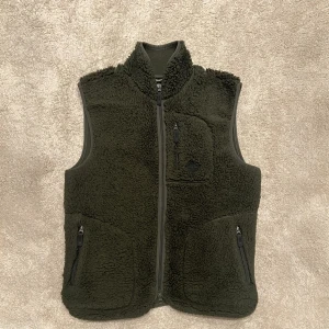 J.Lindeberg väst - Snygg grön J.Lindeberg väst i väldigt bra skick. Den är väldigt varm och bekväm, perfekt nu till vintern. Den är använd men har inga tydliga defekter. Fraktas endast på köparens bekostnad. Storlek S. Kom gärna med bud. 