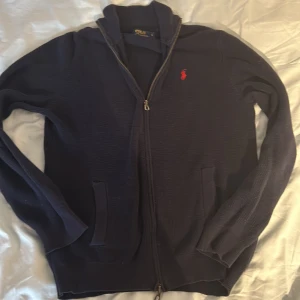 Ralph Lauren Full Zip S-M - Säljer denna snygga Ralph Lauren full zipen i storlek S men sitter som M. Tröjan har inga defekter och är i topp skick. För frågor är det bara att höra av sig.