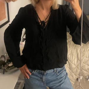 Svart blus - Jättesöt svart blus, väl använd men i gott skick. Snörerba är lite slitna. 