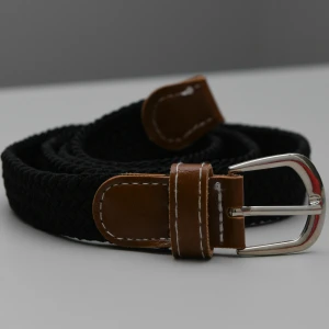 Flätat bälte  - Riktigt snyggt flätat bälte i marinblå färg, med brunt läder! Passar perfekt till fest men lika bra till vardagsbruk. Bältet mäter 100cm. 