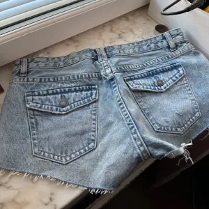 Säljer ett par snygga blå jeansshorts från Pull&Bear i storlek S. De har en cool fransig kant och klassiska femficksdetaljer. Perfekta för sommardagar och festivaler! 🕶️