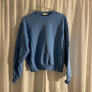 Blå sweatshirt från Gina Tricot - Säljer en snygg blå sweatshirt från Gina Tricot i storlek XS. Den är supermjuk och perfekt för både vardag och mysiga hemmakvällar. Tröjan har långa ärmar och en klassisk rund halsringning. Perfekt för alla säsonger! 💙