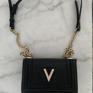 Valentino by Mario väska - En svart lite större väska med silver detaljer som är användbar till vardagslivet. Väskan visar inte större tecken på användning förutom att vissa av de silvriga detaljerna har tappat en aning färg.