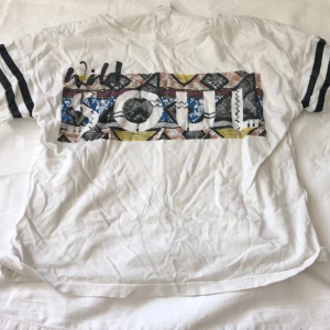 Fin tröja med tryck  - T-Shirt med tryck ”Wild soul” samt ränder på ärmarna från Lindex Kids.