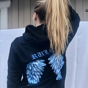 Snygg hoodie - En svart lite tunnare hoodie med blåa vingar på ryggen och en liten text i fram:) Aldrig använd så den är i fint skick 💙 150kr + frakt eller högstbjudande:)