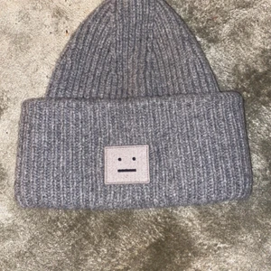 Acne mössa  - Säljer min acne mössa som tyvärr inte längre kommer till användning. Den är i ett bra skick i en fin grå färg. Kan mötas upp i stockholm city eller bromma. Om du vill ha den skickad till sig så tillkommer en fraktkostnad till priset.