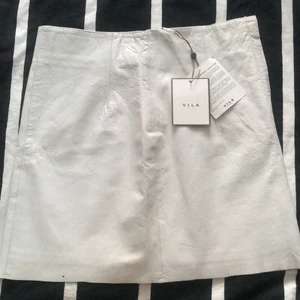 Pongo Leather skirt C white  - Äkta skin kjol från VILA. Sjukt snygg på. Aldrig använd prislapp sitter kvar. Nypris 1099kr. Storlek M men skulle säga den passar även S/36