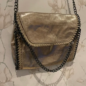 Väska - En liten Stella McCartney inspirerad väska i en fin, festlig guld färg med lite inslag av glitter. Perfekt till fest men även vardags