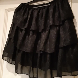 Svartglittrig volangkjol - Svartglittrig volangkjol, aldrig använd. Väldigt stretchig så passar xs-m skulle jag säga💓💕