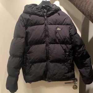 Lacoste dunjacka - Hej! Säljer min sköna och snygga Lacoste vinterjacka. Köpte den för 1 år sedan på Lacostes hemsida för 3800kr. Den är i ett mycket bra skick och har nästan inga skråmor eller flaws. Storleken är S/M och den är lite för liten på mig som är 185 cm lång.