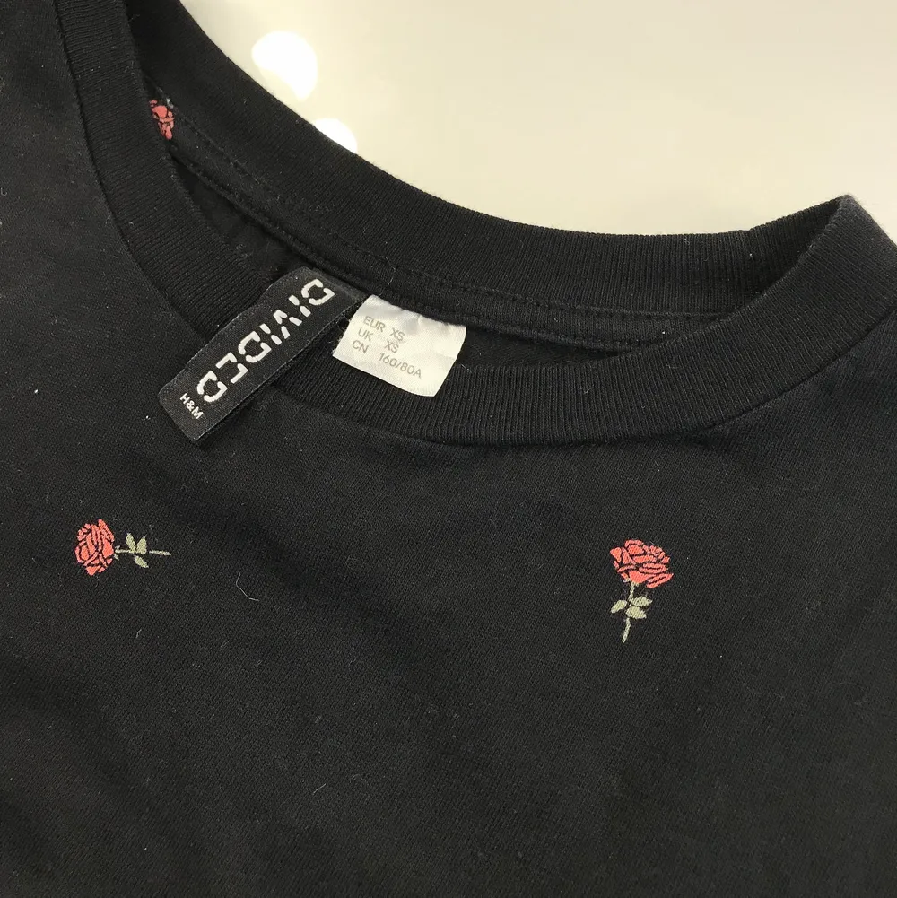 Svart t-shirt från H&M med blommor på. Är i fint skick. Kan mötas upp eller frakta.. T-shirts.