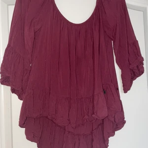 Tessie Blus - Säljer denna jättefina röda blusen eftersom jag inte använder den. Blusen är inte använd mer än 3 gånger och därmed så gott som ny. Kan användas både som off shoulder modell eller vanlig. 