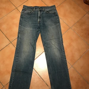 Ljusblåa American Classic jeans W36 L34 - Ljusblåa American Classic jeans i väldigt gott skick. Det enda irriterande med byxorna är att det inte finns dragkejda eller knappar att stänga med (förutom den längst upp). Man stänger byxorna med carboardband. W36 L34. Finns att hämta i Rågsved.