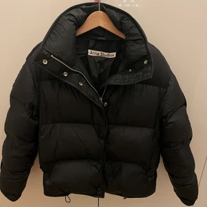 Acne puffer jacket - Acne Puffer Jacka inköpt år 2020.  I väldigt bra skick, inga hål, inga fläckar etc.  Storlek 34.  Acne Studios jackas Black fjäder / nylon. Klassisk jacka från Acne Studios med tratt hals, tryckknapp infästning, främre dragkedja och långa ärmar.