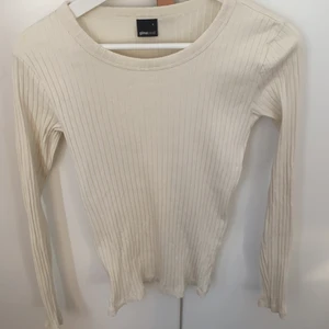 Tajt gräddvit tröja med ribatmönster - En gräddvit tajt och långärmad tröja med ribbat mönster som är köpt på Gina tricot
