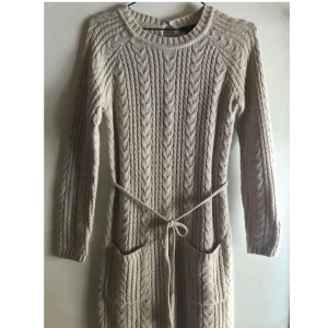 Beige Stickad klänning storlek S - Cosy Beige Stickad klänning storlek S från H&M. Bra skick och inget att anmärka på. Stickad bälte kan tas bort. Längd: 80% akryl - 20% polyamid