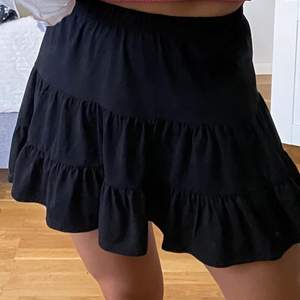 Kort svart kjol med små volanger, oanvänd