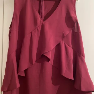 Blus  - Vinröd Blus med volanger i storlek 44, använd fåtal gånger. 