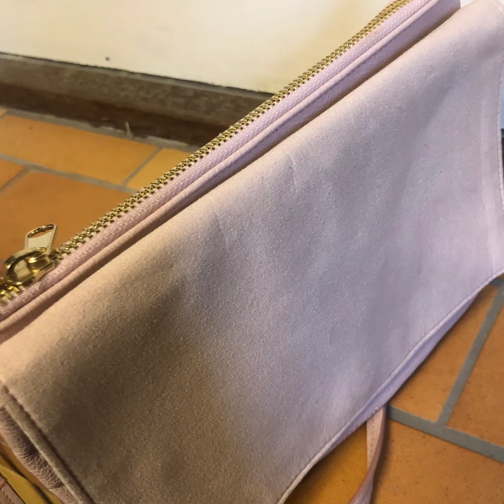Ljusrosa väska i mockaimitation på framsidan och läderimitation på baksidan. Använd fåtal gånger. Kan bäras både som axelremsväska eller som kuvertväska. . Väskor.