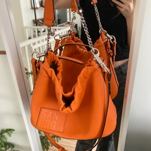 Väska från sandro - HÖGSTA BUD: 1400! Supersnygg väska från sandro. Går att bäras crossbody över axeln armvecket och att hålla i! Fin orange färg. Perfekt till våren och sommaren. Buda i kommentarerna!