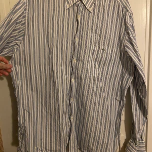 Lacoste skjorta - Rutig Lacosteskjorta i strlk L/XL. Väldigt fräsh och knappt använd. 