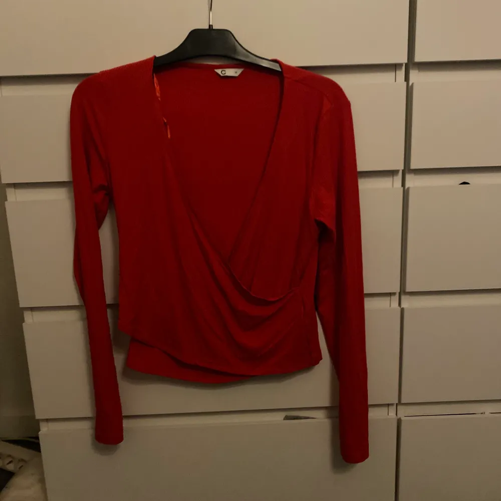En fin röd tröja som är typ korsad, aldirg använd. . Toppar.